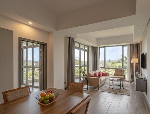 ein Wohnzimmer mit einem Tisch, Stühlen und einem Sofa in der Unterkunft Dusit Princess Hotel Residences Nairobi in Nairobi