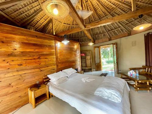 a bedroom with a large bed in a wooden wall at Tilagaon Eco Village in Sreemangal