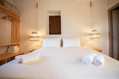 a bedroom with a white bed with towels on it at ΠΥΡΓΟΣ ΜΠΕΧΡΑΚΗ-Μάνη in Pirgos Dhirou