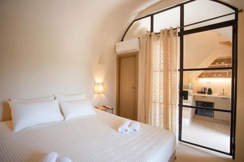 a bedroom with a white bed and a window at ΠΥΡΓΟΣ ΜΠΕΧΡΑΚΗ-Μάνη in Pirgos Dhirou