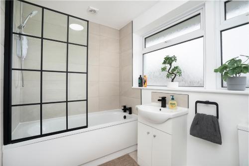LincolnshireにあるModern 3 Bed House-Free Parkingの浴槽と洗面台と窓のあるバスルーム