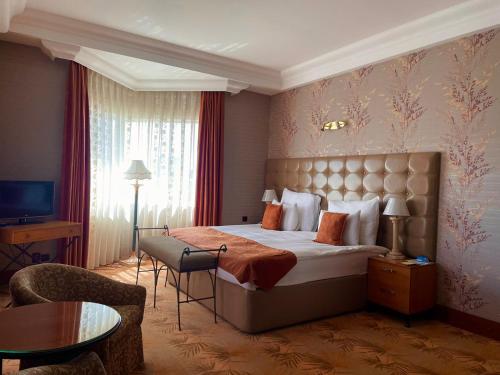 a hotel room with a large bed and a television at Grand Hotel Europe in Baku