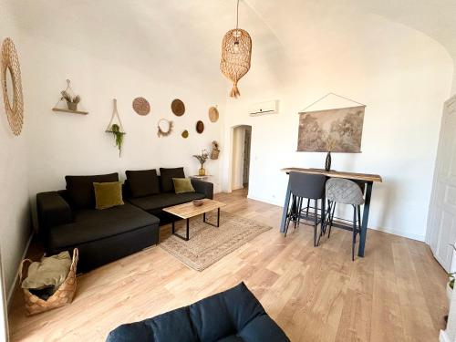 uma sala de estar com um sofá preto e uma mesa em Grand T2 - Centre ville -10 min de la plage à pied em Ajaccio