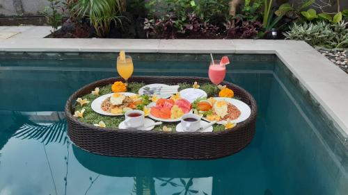 un vassoio di cibo su un tavolo in piscina di La Fortuna a Seminyak