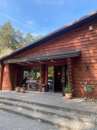a wooden building with stairs leading to a door at Alytaus Kempingas in Alytus