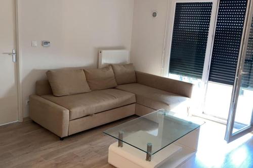 un salon avec un canapé et une table en verre dans l'établissement Appartement idéalement situé à2min à pied du Tram2, à Castelnau-le-Lez