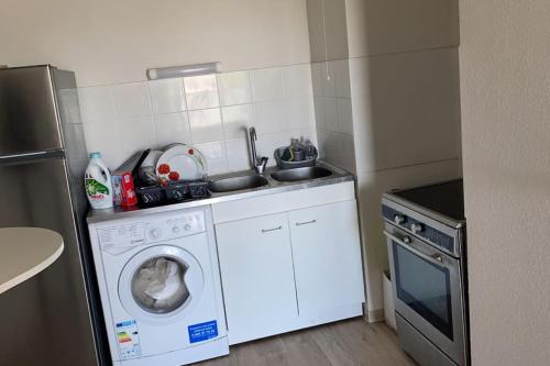 une cuisine avec un lave-linge et un lave-vaisselle dans l'établissement Appartement idéalement situé à2min à pied du Tram2, à Castelnau-le-Lez