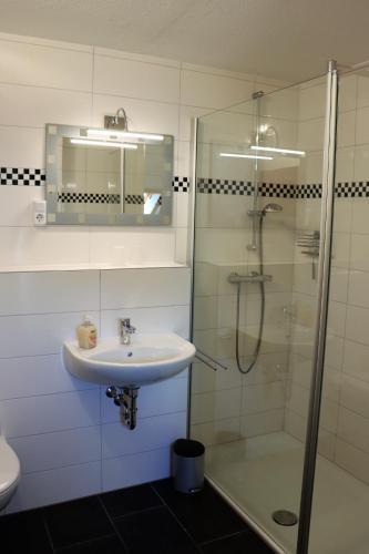 a bathroom with a sink and a shower at Übernachten im Café Restaurant Vedder in Herscheid