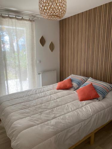 1 dormitorio con 1 cama grande y 2 almohadas rojas en Résidence Domaine de Lumière, en Saint-Jean-de-Monts