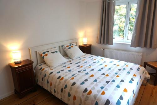 a bedroom with a bed with two lamps and a window at Gîte Les Hirondelles - maison typique - centre village - proche vignoble in Scherwiller