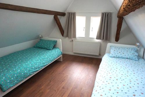 a bedroom with two beds and two windows at Gîte Les Hirondelles - maison typique - centre village - proche vignoble in Scherwiller