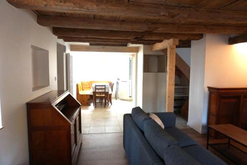 a living room with a blue couch and a table at Gîte Les Hirondelles - maison typique - centre village - proche vignoble in Scherwiller