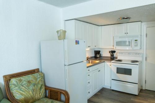 a kitchen with a white refrigerator and white appliances at Beach Club at Montego Inn in Myrtle Beach