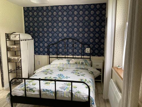 Schlafzimmer mit einem Bett mit blauer Wand in der Unterkunft La Maison Bleue in Préveranges