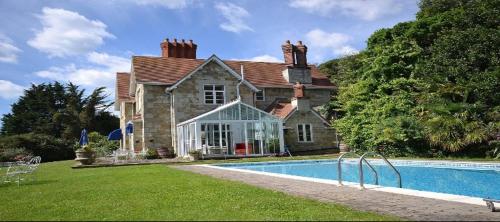 a house with a swimming pool in front of it at TORWOOD VICTORIAN HOUSE in Ventnor