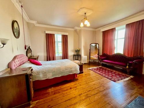 a bedroom with a large bed and a couch at TORWOOD VICTORIAN HOUSE in Ventnor
