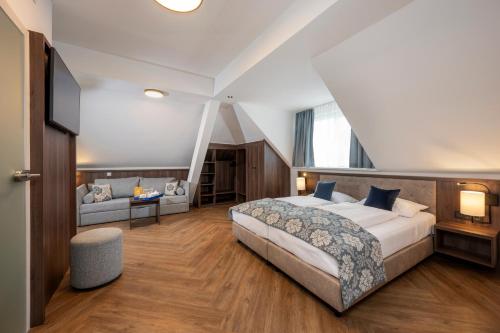 1 dormitorio con 1 cama grande y 1 sofá en Salzburg Hotel Lilienhof, en Salzburgo