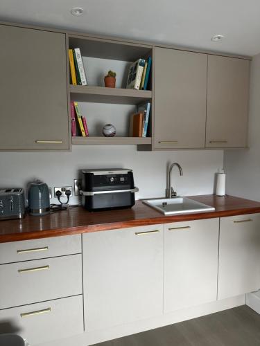 a kitchen with white cabinets and a sink at Number One Townhouse in Kinsale