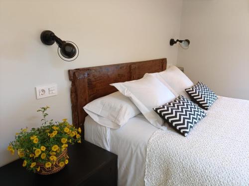 a bedroom with a bed with a vase of flowers on a table at Belaustegi turismo rural in Ispáster