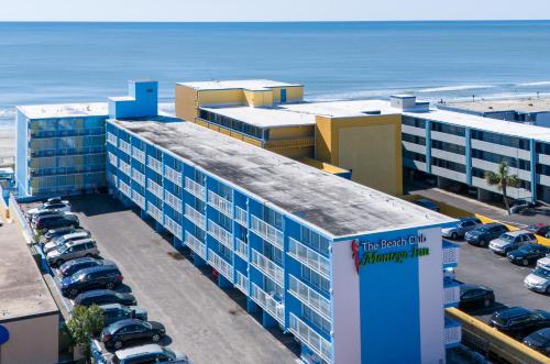 a large building with cars parked in a parking lot at Beach Club at Montego Inn in Myrtle Beach