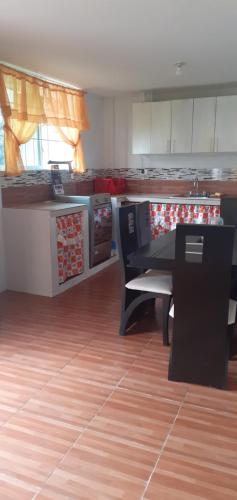a kitchen with a counter and a table in a room at Casa campestre en una comunidad ancestrar bajo las faldas del Taita Imbabura in San Juan de Ilumán