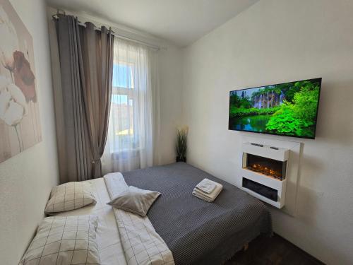 a bedroom with a bed with a tv on the wall at 8 Small studio apartment in Klaipėda