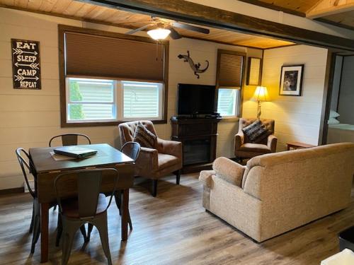 a living room with a couch and a table and chairs at Cloverleaf Cottages in Oxtongue Lake