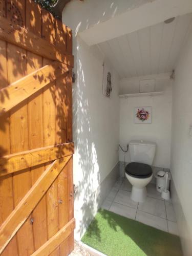 une salle de bain avec toilettes et porte en bois dans l'établissement Le mazet, à Poussan