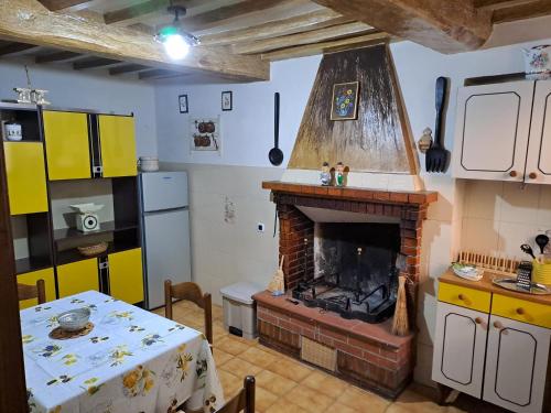 センプロニアーノにあるla casina della bubbolinaのキッチン(テーブル、暖炉付)