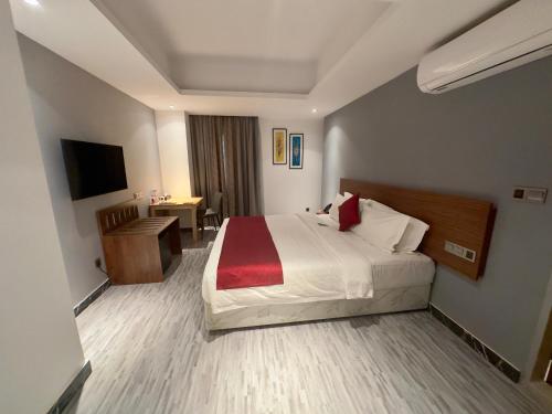 a hotel room with a large bed and a desk at Hotel Omni Residency Baridhara in Dhaka