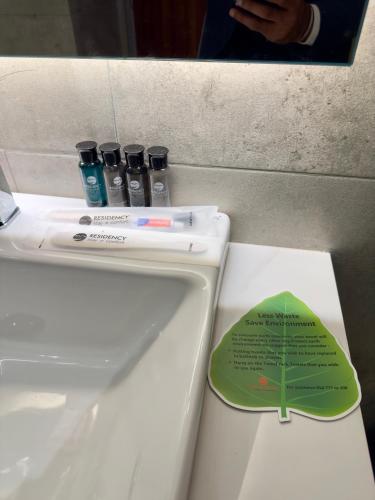 a white sink with three bottles on top of it at Hotel Omni Residency Baridhara in Dhaka