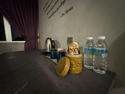a table with two bottles of water on it at Ipoh Zing Vale - Family & Couple Suite in Ipoh