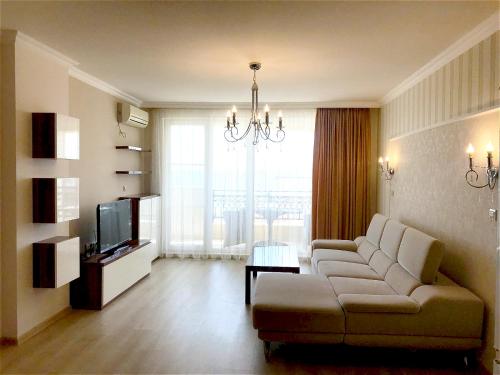uma sala de estar com um sofá e uma televisão em Private Super apartments by sea in Apart Hotel ! em Pomorie