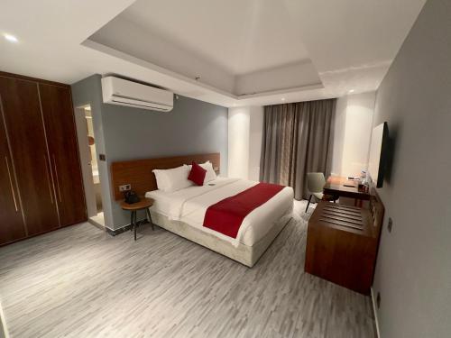 a hotel room with a large bed and a television at Hotel Omni Residency Baridhara in Dhaka