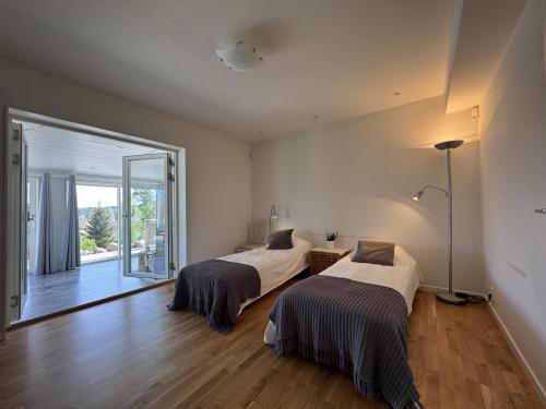 een slaapkamer met 2 bedden en een groot raam bij Lovely villa with a view of the Byfjorden and Uddevalla in Uddevalla
