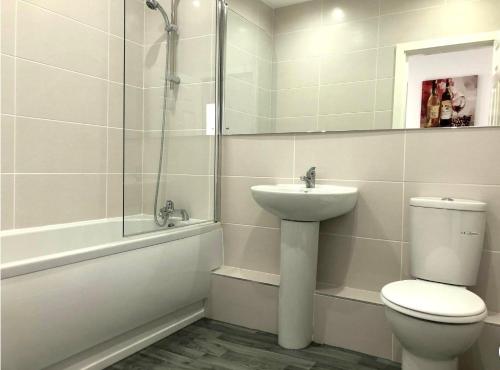 a bathroom with a toilet and a sink and a shower at Fabrik: Winter Gardens Service Apartments 2 in Blackpool