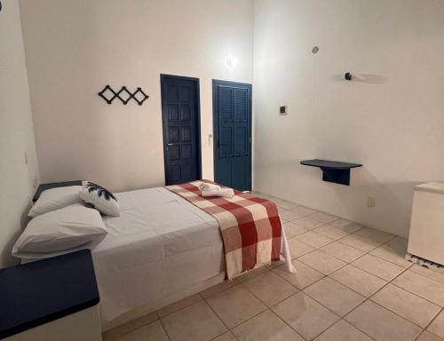 - une chambre avec un grand lit et des portes bleues dans l'établissement Pousada Palamós Uruaú, à Beberibe
