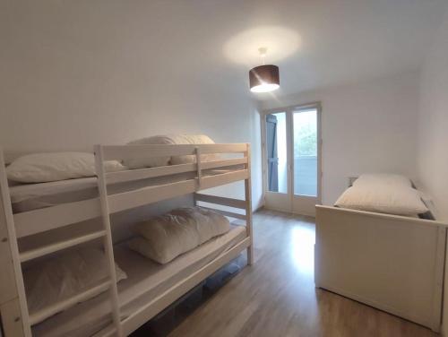 deux lits superposés dans une chambre avec fenêtre dans l'établissement Appart 4 p au calme vue forêt, à Saint-Jean-de-Monts