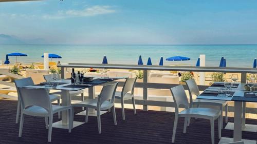 a table and chairs on a balcony with the beach at Hotel La Battigia in Alcamo Marina