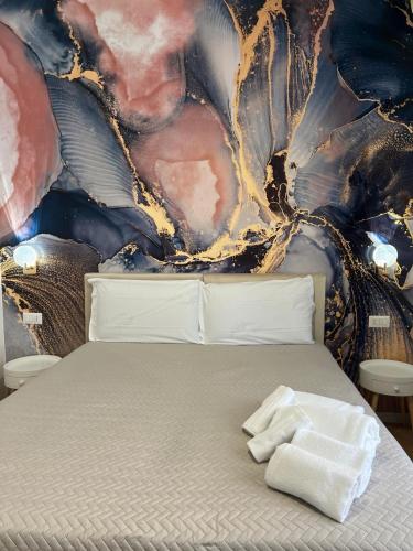 a bed in a room with a painting on the wall at Le Corti del Re in Naples