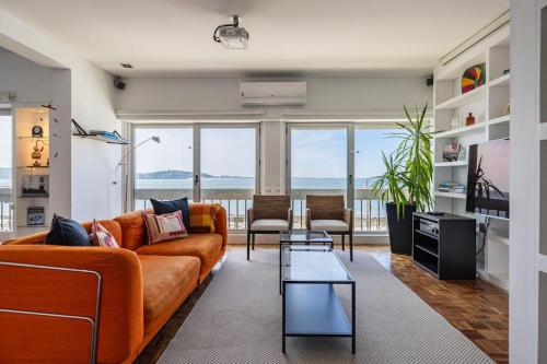a living room with a couch and a table at Unique Riverview Apartment in Cruz Quebrada