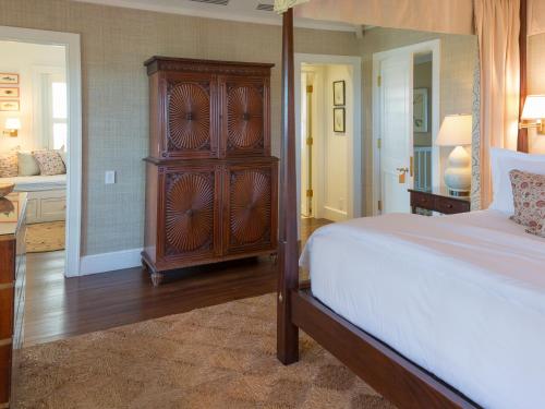 a bedroom with a bed and a wooden dresser at Eleven Bahama House in Harbour Island