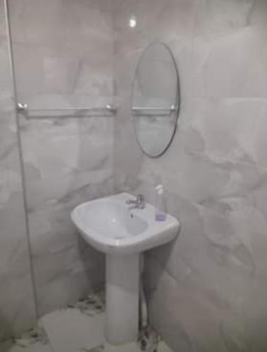W białej łazience znajduje się umywalka i lustro. w obiekcie صلامندر w mieście La Salamandre