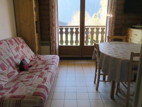 un salon avec un canapé, une table et une fenêtre dans l'établissement Appartement Convivial pour 4 Personnes avec Balcon et Parking à Châtel - FR-1-198-89, à Châtel