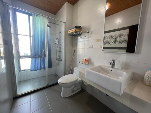a bathroom with a sink and a toilet and a shower at Come Home Travel in Tainan