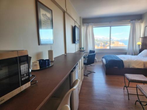 Habitación de hotel con cama y cocina con microondas en Buena Vista en San Carlos de Bariloche