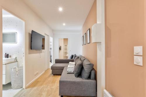 un salon avec un canapé et une télévision dans l'établissement Charme Parisien 6 Personnes, 2 chambres, 19ème, à Paris