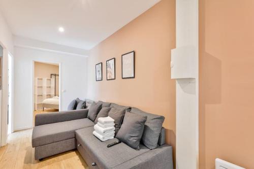 - un salon avec un canapé gris dans l'établissement Charme Parisien 6 Personnes, 2 chambres, 19ème, à Paris