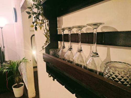 una fila de copas de vino en un estante en Strawberry Swing Homestay, en Guwahati