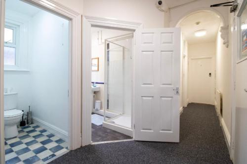 a bathroom with a white door and a toilet at Pebbles Guest House in Southampton